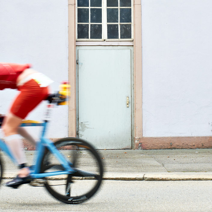 Ein Radfahrer vor einer Gebäudemauer