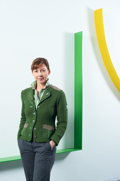 Portrait einer Dame vor weisser Wand grünem und gelbem Streifen