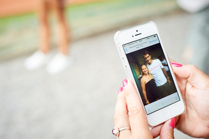 Eine Handybesitzering zeigt stolz ihr Bild mit Roger Federer