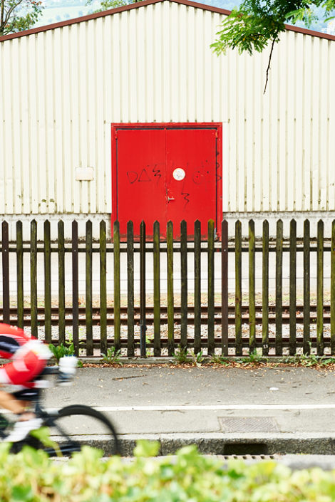Triathlet auf dem Rad vor einem Zaun
