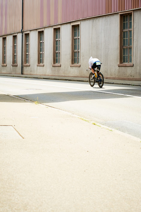 Triathlet auf dem Rad vor einem Gebäude