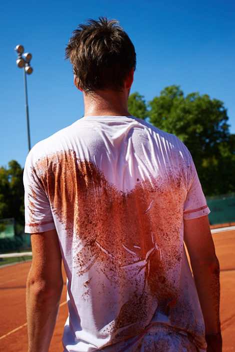 Sand auf dem Shirt am Rücken eines Tennisspielers