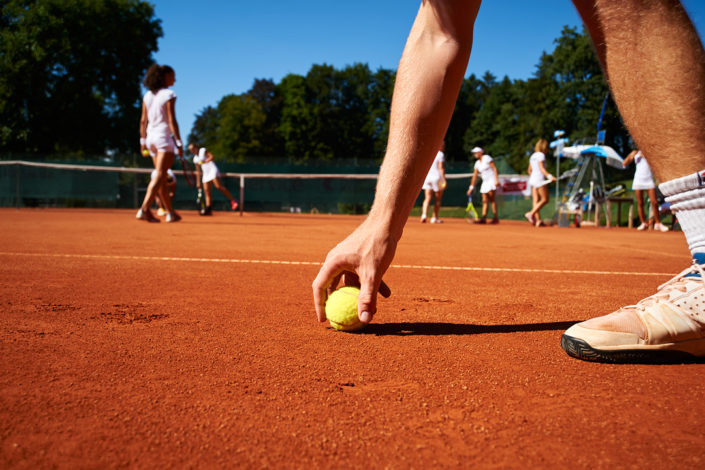 Der Trainer nimmt einen Ball auf