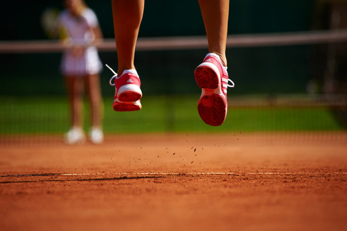 Füsse einer Tennisspielerin in der Luft