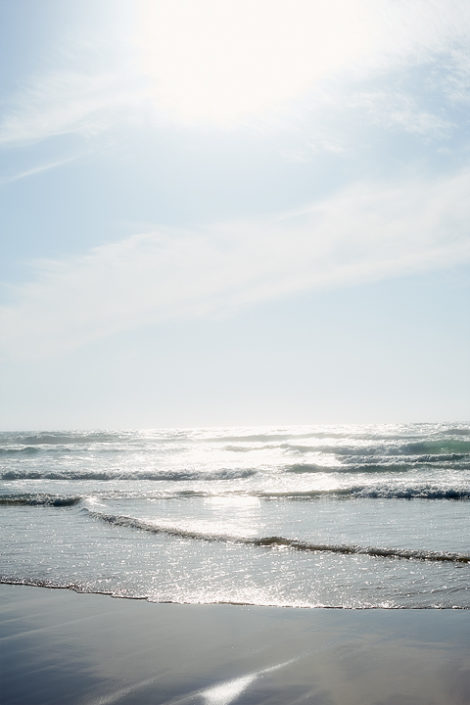 Die kleinen Wellen am flachen Strand glitzern in der Sonne