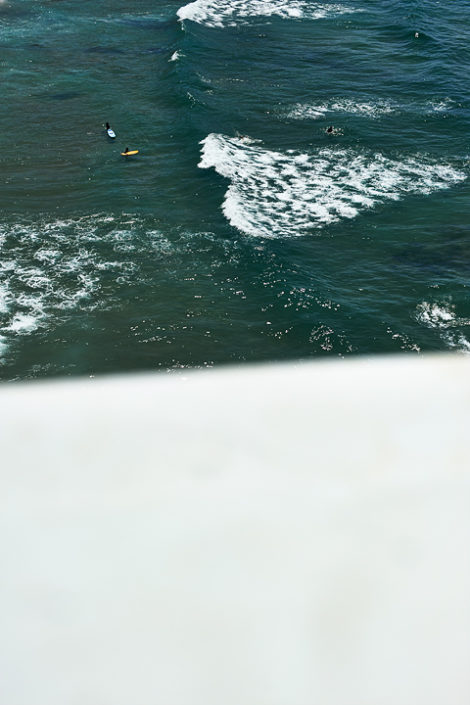 Blick von oben auf Wellenreiter im Meer