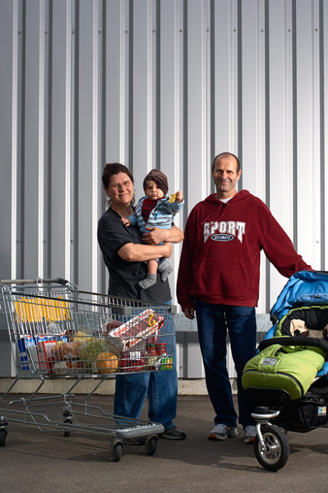 Eine junge Familie präsentiert ihre Einkäufe