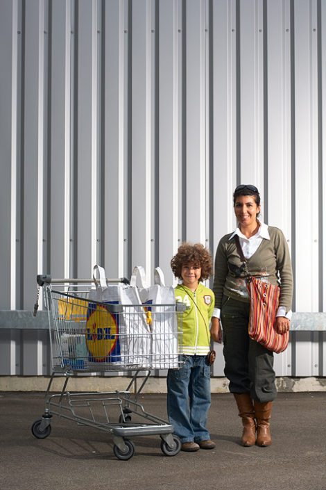 Eine Mutter und ihr Kind präsentieren ihre Einkäufe im Einkaufswagen