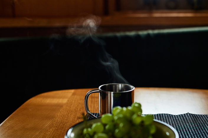 Eine Kaffeetasse mit dampfendem Kaffee steht auf einem Tisch