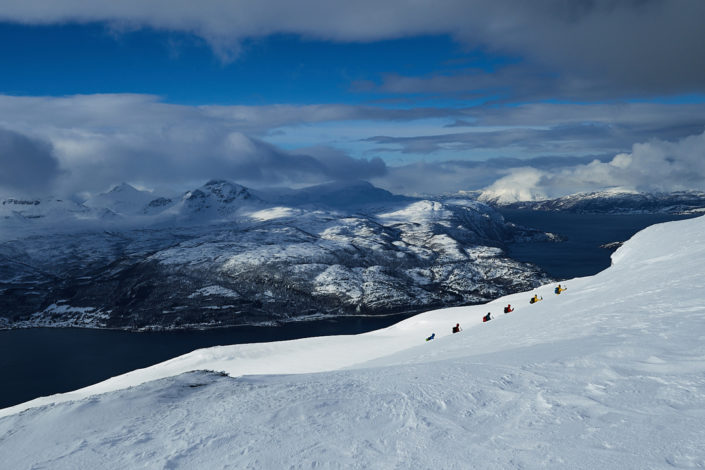 Aussicht auf die Fjordlandschaft mit Skitourengruppe im Vordergrund