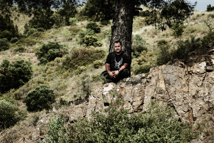 Fredi Torres von Fredi Torres Viticultor sitzt vor einem Baum in seinem Rebberg