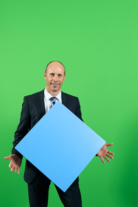 Portrait mit Person vor grüner Wand und blauem Viereck