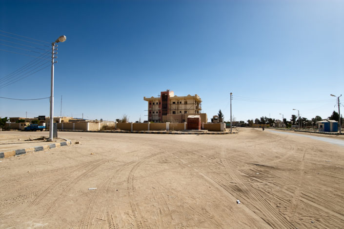 Ein Gebäude am Rande eines Sandplatzes