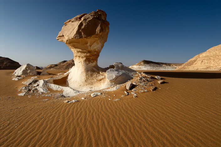 Ein Felsenpilz ragt aus dem Wüstensand