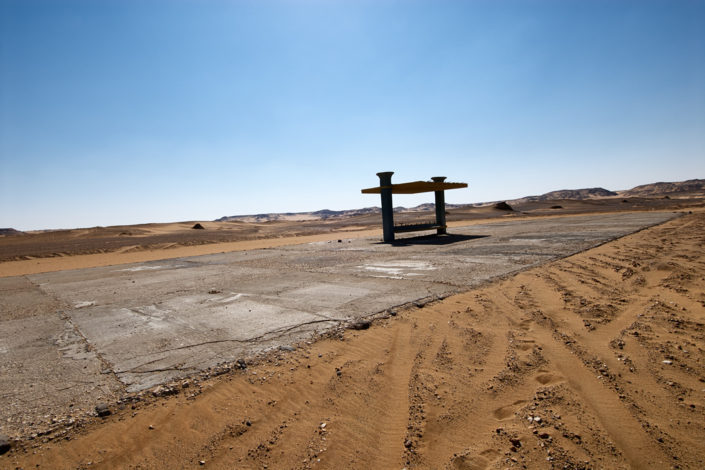 Eine zerfallene Betonkonstruktion steht auf dem Wüstenboden