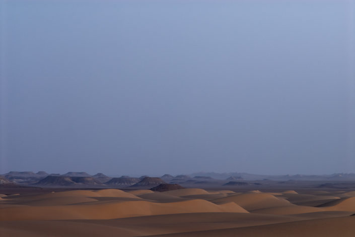 Das letzte Abendlicht lässt die Dünen in der Ferne erleuchten