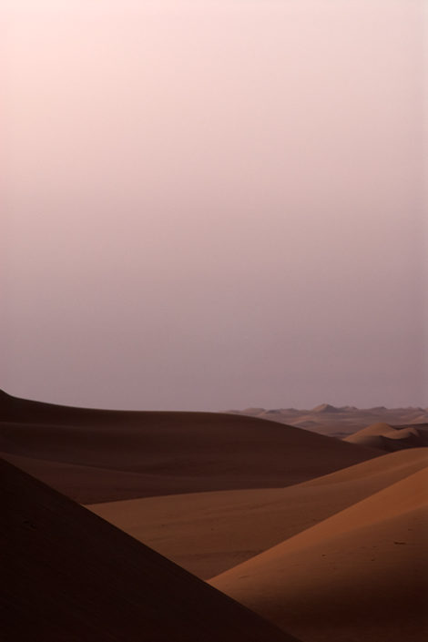 Das erste Morgenlicht lässt die Dünen in rosa Licht erscheinen