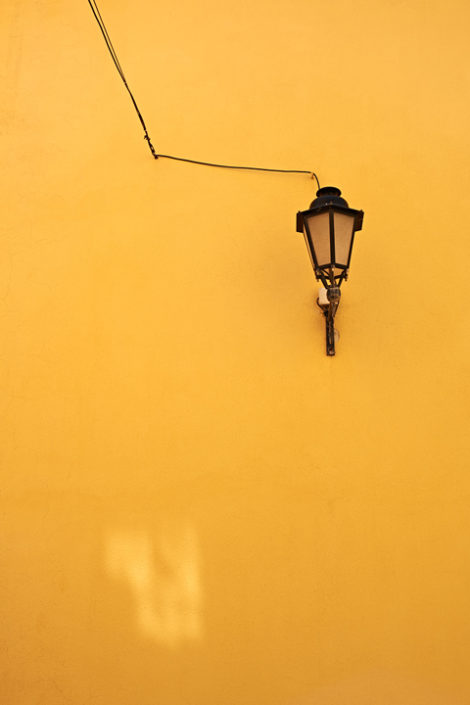 Eine Lampe an einer gelben Hauswand in St. Tropez